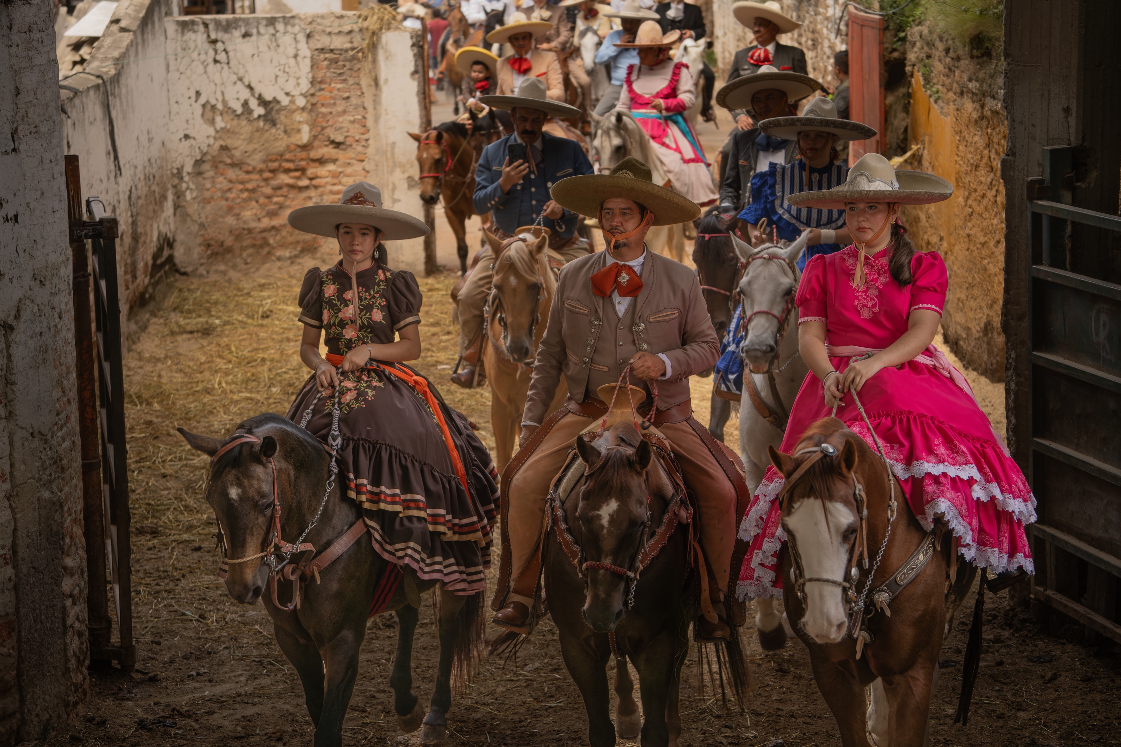 Desfile de charros y escaramuzas a caballo por calle colonial de Guadalajara