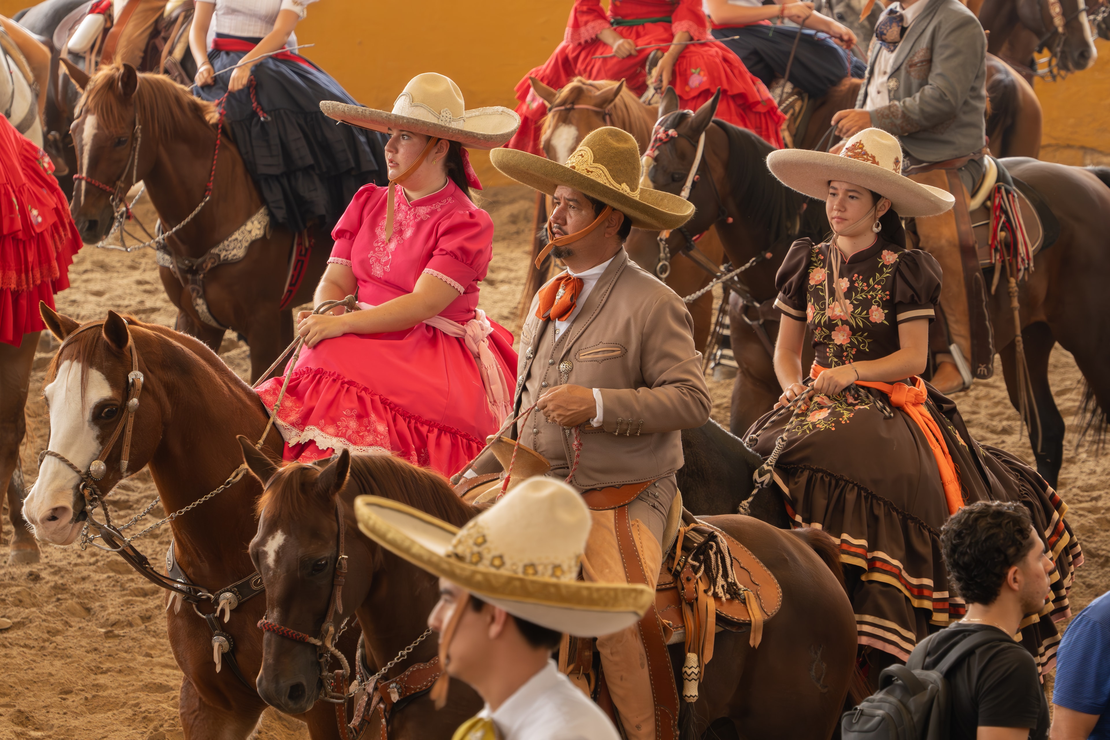 Escaramuzas y charro a caballo con trajes típicos coloridos en el Lienzo Charro