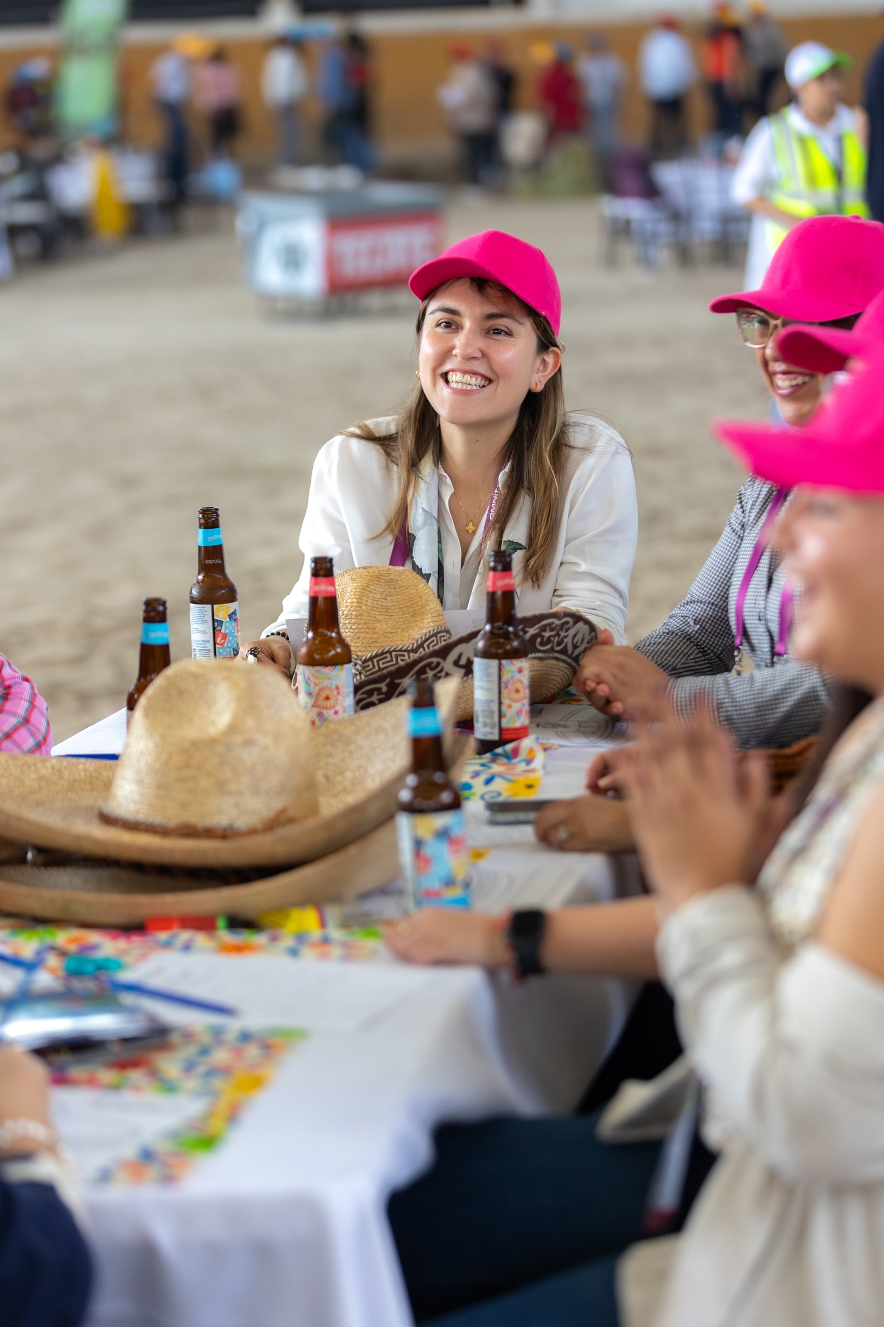 Grupo con gorras rosas disfrutando bebidas en el Lienzo Charro