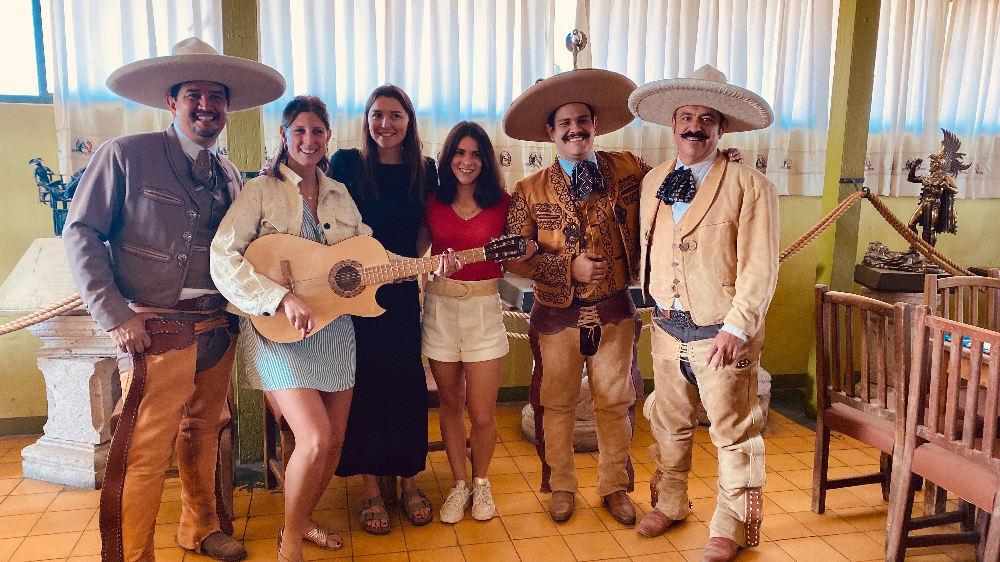 Charros con visitantes tocando guitarra